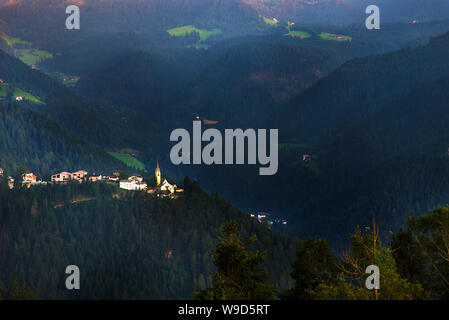 Eine kleine Stadt bei Sonnenuntergang, auf die Dolomiten und den Alpen. Stockfoto