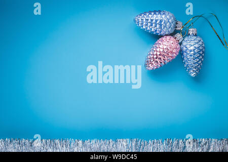 Lakonisch und kreative Gestaltung im modernen Stil auf blauem Hintergrund. Weihnachtsdekoration. Festliche Karte mit silbernen Kugeln, glänzenden Spielzeug. Helle Vorlage, Muster Stockfoto
