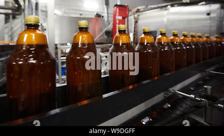 Der neue Kunststoff Flaschen auf dem Transportband am Bier trinken. Trinkwasser Fertigungsprozess. Flache Freiheitsgrad. Selektive konzentrieren. Stockfoto