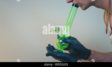 Die Person hält in seiner Hand Bong mit frischen medizinisches Marihuana Knospen. Konzept der Rauchen von Cannabis. Hanf ist eine pflanzliche Arzneimittel Stockfoto