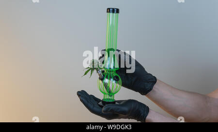 Die Person hält in seiner Hand Bong mit frischen medizinisches Marihuana Knospen. Konzept der Rauchen von Cannabis. Hanf ist eine pflanzliche Arzneimittel Stockfoto