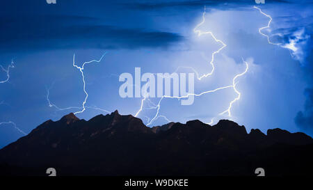 Panorama der Gewitter Blitzschlag über Berg mit dunklen bewölkter Himmel Hintergrund in der Nacht. Stockfoto