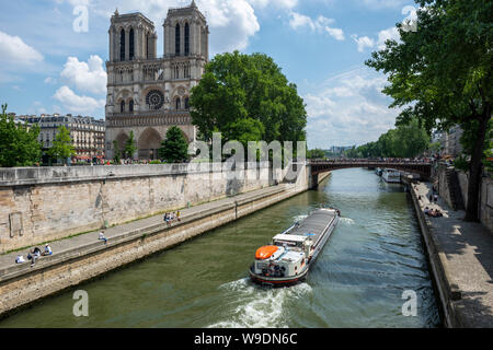 Schiff auf dem Fluss Seine Annäherung an Pont au Double Bridge mit der Kathedrale Notre-Dame auf der linken Seite, Ile de la Cité, Paris, Frankreich Stockfoto
