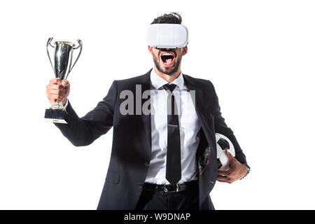 Aufgeregt Geschäftsmann in virtual reality Headset mit Fußball und Trophy cup isoliert auf weißem Stockfoto