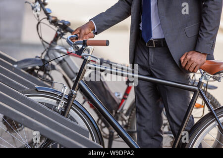 Teilweise mit Blick auf die afrikanische amerikanische Geschäftsmann Fahrrad von Parken Stockfoto