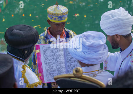 Gonder, Äthiopien, 18. Januar 2019: Priester in der traditionellen Kleidung der Timkat Festival feiern, durch das Lesen von einer Amharischen Bibel Stockfoto