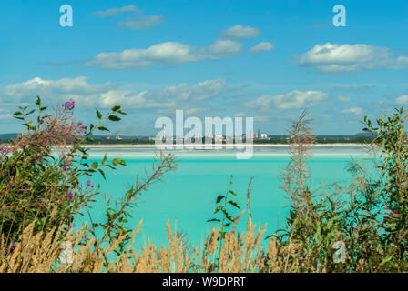 Industrielle Bergeteich mit schönen blauen Wasser auf dem Hintergrund der Fabrik Landschaft Stockfoto