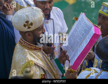 Gonder, Äthiopien, 18. Januar 2019: Priester in der traditionellen Kleidung der Timkat Festival feiern, durch das Lesen von einer Amharischen Bibel Stockfoto