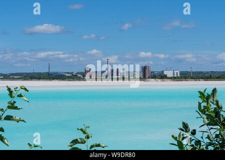 Industrielle Bergeteich mit schönen blauen Wasser auf dem Hintergrund der Fabrik Landschaft Stockfoto