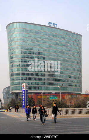 ------ Lokale chinesische Bewohner zu Fuß durch die Zentrale und Hauptverwaltung der CNOOC (China National Offshore Oil Corporation) in Peking, März Stockfoto