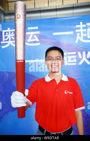 Zhang Jun, dem Designer der Wolken der Versprechen, die offizielle Fackel der Olympischen Spiele 2008 in Peking, hält eine Fackel während einer Road Show in Wuhan City, s Stockfoto