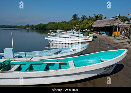 Fischerboote namens Pangas Strände am Rande des Sontecomapan Lagune bei La Barra de Sontecomapan, Veracruz, Mexiko. Die Lagune, die fliesst in den Golf von Mexiko ist eines der am besten erhaltenen Feuchtgebiete im Küstenbereich und Mangroven Wälder in Mexiko und ein Teil der Los Tuxtlas Biosphärenreservat. Stockfoto