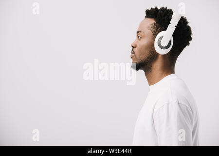 Seitenansicht der afrikanischen amerikanischen Mann Musik hören über Kopfhörer auf Weiß Stockfoto
