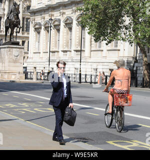 Westminster, London, UK, 13. Aug 2019. Ein sonnenanbeter in einem Bikini, und sonst nicht viel, Zyklen, Whitehall in Westminster. Nach Tagen des Regens und kühlere Temperaturen, das warme Wetter kennzeichnet eine willkommene Abwechslung für die Londoner. Credit: Imageplotter/Alamy leben Nachrichten Stockfoto