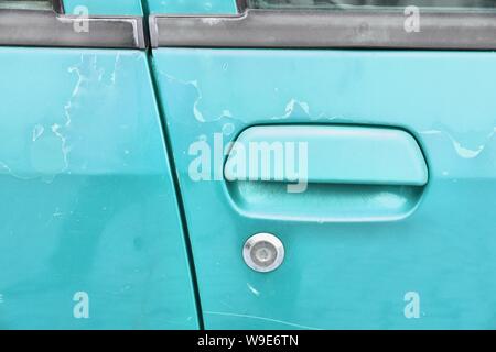 Fading Autolack - abblätternde Farbe Oberfläche in einem 20 Jahre alten Europäischen rotes Auto. Stockfoto