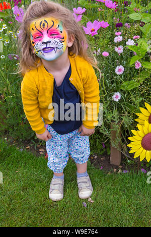 Lola 2.5 mit gemalten lion Gesicht unter den Blumen am New Forest & Hampshire County, New Milton, Hampshire Großbritannien im Juli im Alter von Stockfoto