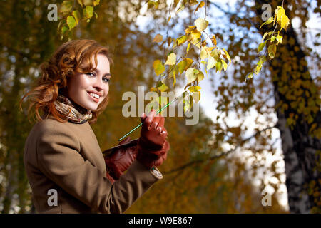 Schöne Frau mit Palette und Pinsel Lacke Farben Blätter an den Bäumen Stockfoto