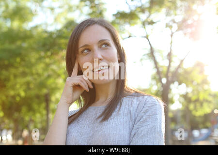 Nachdenklich, glücklich erwachsenen Frau an der Seite stehen in einem Park suchen Stockfoto