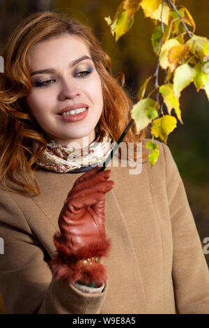 Schöne Frau mit Palette und Pinsel Lacke Farben Blätter an den Bäumen Stockfoto