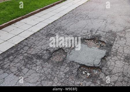 Beschädigte Straße in Göteborg, Schweden. Konzept für die Instandhaltung der Straßen. Stockfoto