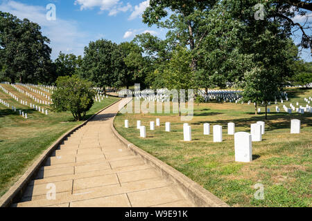 Ein Wanderweg führt durch den Arlington National Friedhof in Arlington, Virginia, mit Reihen von weißen Stein, militärische ernste Markierungen Stockfoto