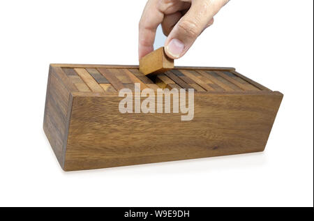 Hand sammelt Stücke Holz- Ziegel in der Box nach dem Spiel Jenga Spiel, Bausteine Holz Jenga Spiel auf weißem Hintergrund. Stockfoto