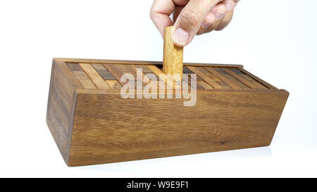 Hand sammelt Stücke Holz- Ziegel in der Box nach dem Spiel Jenga Spiel, Bausteine Holz Jenga Spiel auf weißem Hintergrund. Stockfoto