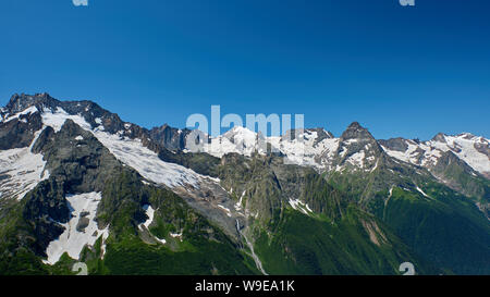 Berggipfel mit einem Gletscher und der Beginn einer Mountain Stream, fließt durch einen Pinienwald. Nördlicher Kaukasus, Russland Stockfoto