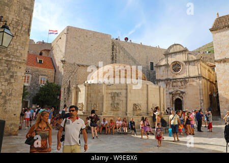 DUBROVNIK, KROATIEN - Juli 11,2019: Touristen Besuche großer Onofrio Brunnen und Kirche St. Saviour auf dem Platz in der Altstadt von Dubrovnik, Kroatien. Stockfoto