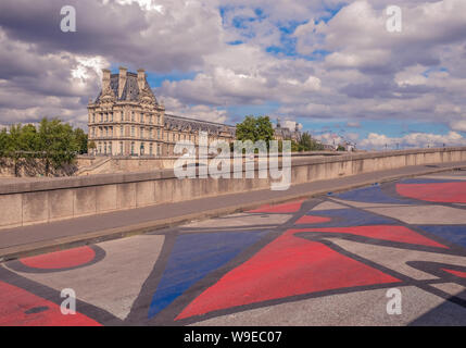 Museum Louvre, Paris, Frankreich, 30. Juli 2018: Buntes Mosaik auf dem Pflaster der Straße mit dem Louvre Museum im Hintergrund gemalt Stockfoto