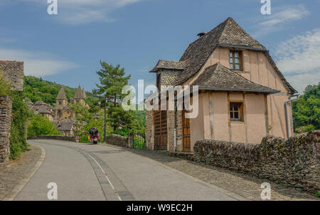 Conques, Midi Pyrenees, Frankreich - 31. Juli 2017: Typisches Haus am Eingang des Dorfes von Conques mit der Kathedrale von Sainte Foy an der Rückseite Stockfoto