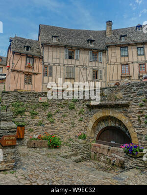 Conques, Midi Pyrenees, Frankreich - 31. Juli 2017: kleine Steinerne Brunnen auf dem Platz der Kathedrale von Conques Stockfoto