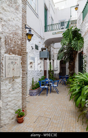 Garten mit Tisch und Stühlen in der Altstadt in Olhao, Algarve, Portugal. Stockfoto