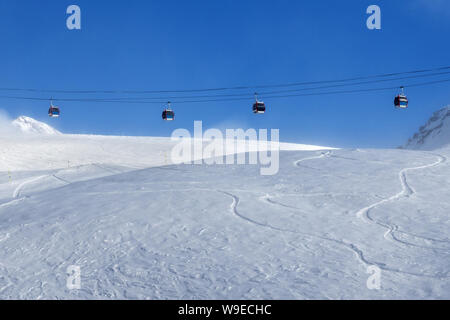 Gondelbahn und verschneite Pisten Skipiste in Nebel auf schönen sonnigen Abend. Kaukasus Berge im Winter, Georgien, Region Gudauri. Stockfoto