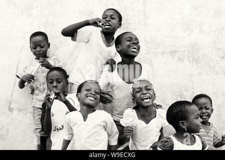 Junge happy singers Praxis einen traditionellen Tanz in den Straßen von Accra, Ghana Stockfoto