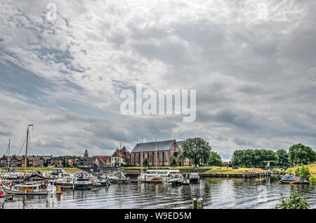 Vollenhove, Niederlande, 4. August 2019: spektakuläre Wolkenformationen über dem alten Städte in der Waterfront mit Marina und Kirche Stockfoto