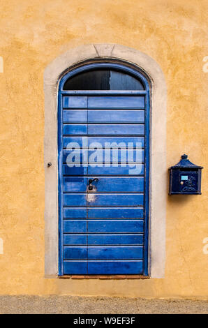Blaue Tür mit ockerfarbenen Wände Stockfoto