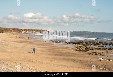 Paar auf Seaham North Beach mit Sunderland in der Ferne, Co Durham, England, Großbritannien Stockfoto