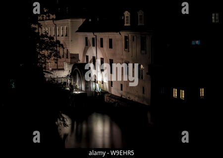 Historische Wassermühle (Velkoprevorsky Mühle) von der Karlsbrücke (Karluv Most) bei Nacht gesehen. Certovka Fluss, Prag, Tschechische Republik Stockfoto