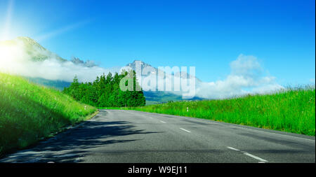 Asphalt unter den Feldern vor dem Hintergrund einer Berglandschaft. Stockfoto