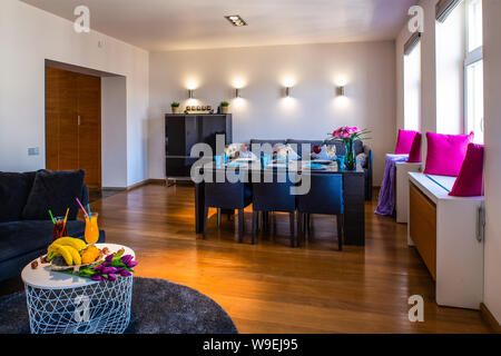 Gedeckter Tisch im Wohnzimmer. Obst und Blumen auf den kleinen Tisch. Stockfoto