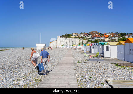 Sonnenanbeter und farbigen Kabinen am Strand/Kiesstrand in Criel-sur-Mer im Sommer, Seine-Maritime, Normandie, Frankreich Stockfoto