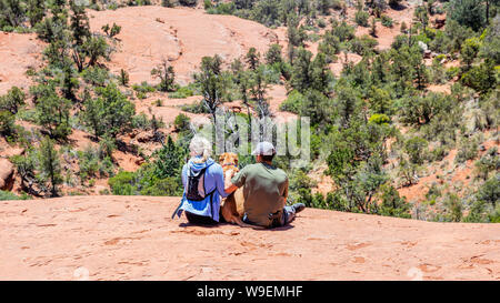 Sedona Arizona USA. 25. Mai 2019. Junges Paar und ein Hund Haustier an der Aussicht auf dem Gelände suchen. Rot Orange wüste Landschaft, blauen Himmel, sonnig Autolöscher Stockfoto