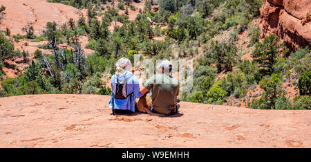 Sedona Arizona USA. 25. Mai 2019. Junges Paar und ein Hund Haustier an der Aussicht auf dem Gelände suchen. Rot Orange wüste Landschaft, blauen Himmel, sonnig Autolöscher Stockfoto