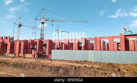 Große Anzahl von turmdrehkränen sind auf der Baustelle, an einem sonnigen Tag installiert. Stockfoto