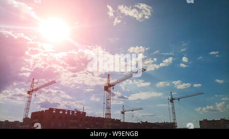 Große Anzahl von turmdrehkränen sind auf der Baustelle, an einem sonnigen Tag installiert. Stockfoto