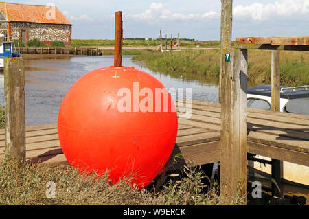 Einen Blick auf eine große rote Boje auf der Kaimauer im Hafen von Thornham North Norfolk, Norfolk, England, Vereinigtes Königreich, Europa. Stockfoto