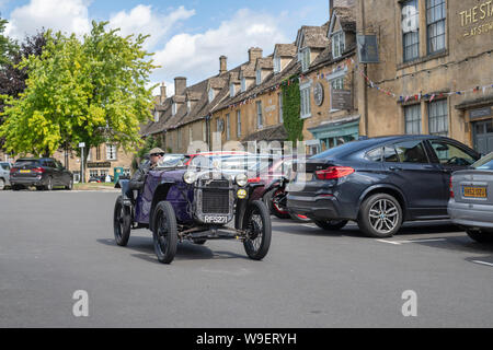 Mann, der ein Austin Seven Auto 1926 in Wold, Cotswolds, Gloucestershire, England Stockfoto