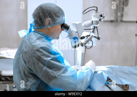 Augenarzt Chirurg durch OP-Mikroskop schwer tun. Stockfoto