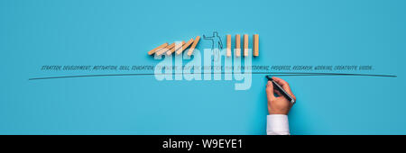 Geschäftsmann stoppen fallende Dominosteine über blauen Hintergrund und männlichen Hand schreiben Business verwandte Wörter. Stockfoto